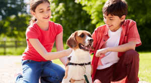 Two children sitting outside with a dog that was found with a microchip